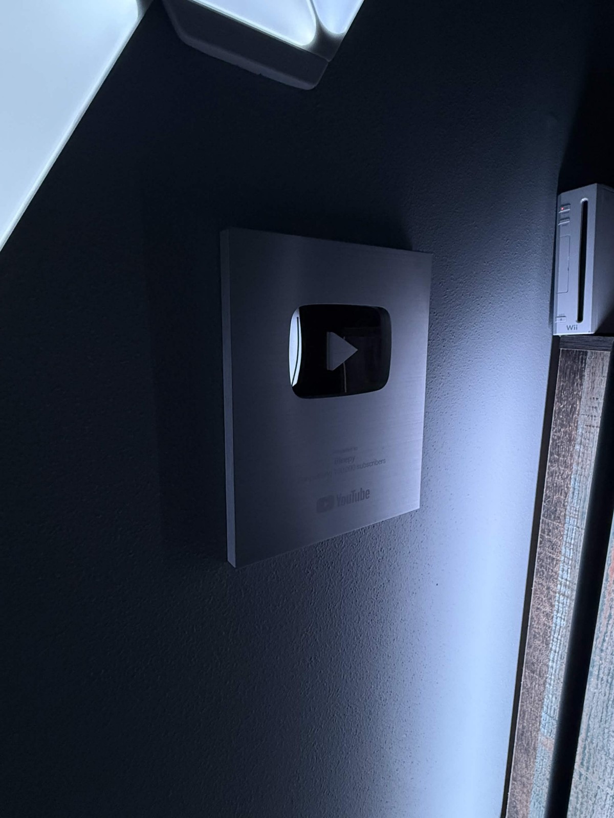 YouTube creator award mounted on a dark wall