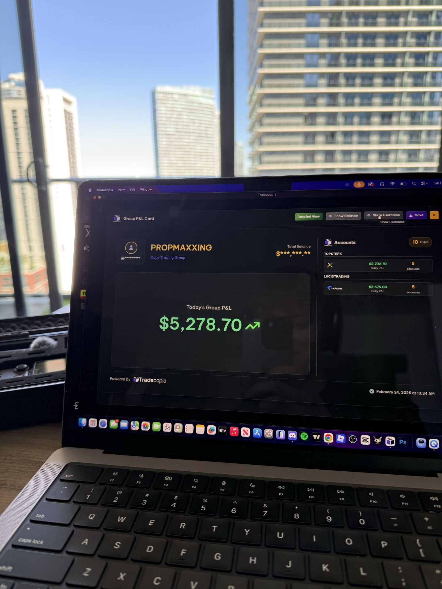 Trading results displayed on a laptop in a city-view workspace